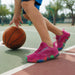 Barn dribblar basketboll utomhus iklädd rosa Barfotaskor Active med färgglada sulor.