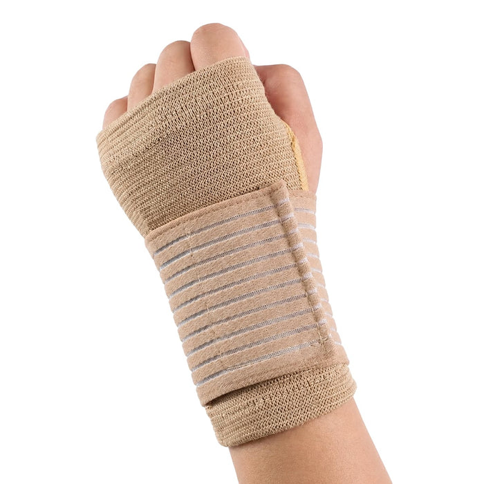 Hand med beige elastiskt handledsstöd från Kroppsbutiken, knuten näve, mot vit bakgrund.