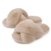 Beige vintertofflor i fluffigt material, med korslagda remmar och halkfri sula, mot vit bakgrund.