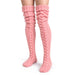 Rosa, stickade knästrumpor av modellen Cozysocks på benen.