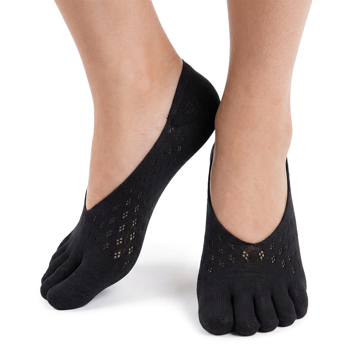 En person med svarta tåstrumpor från Kroppsbutiken, avsedda för hallux valgus, står mot en vit bakgrund.