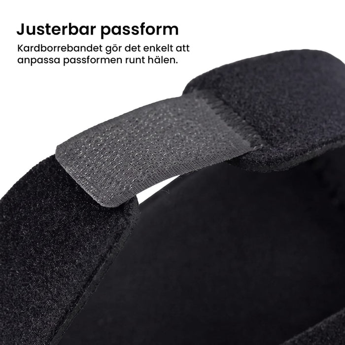 Närbild på en hälkudde mot hälsporre från Kroppsbutiken, med svart justerbar kardborreband och svensk text.
