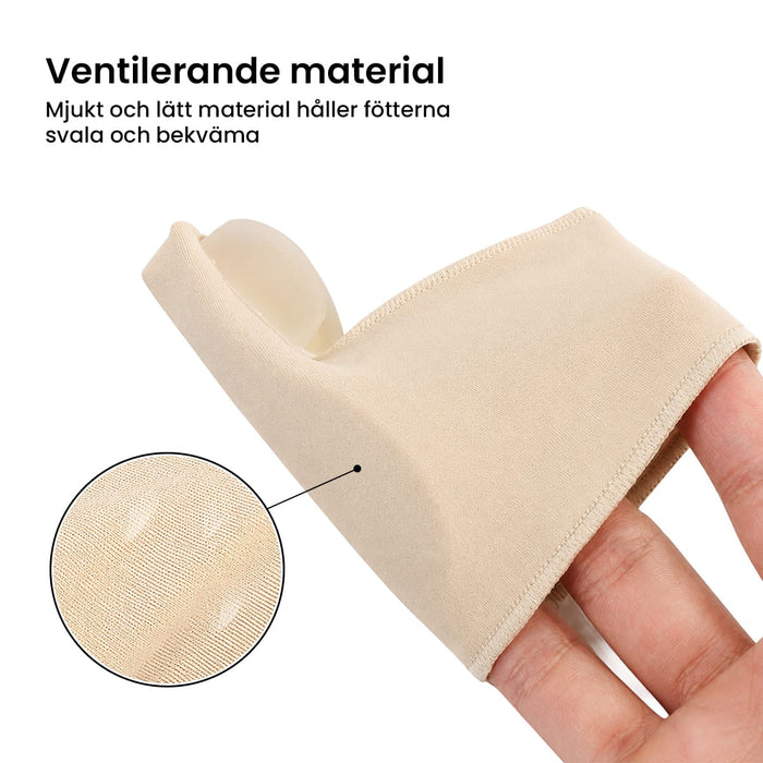 En hand visar upp ett beige tåskydd för hallux valgus, tillverkat av ett mjukt, tunt och luftgenomsläppligt material.