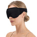 En kvinna med blont hår i en låg knut bär en 3D-sömnmask från Kroppsbutiken, fotograferad från sidan mot en enkel bakgrund.