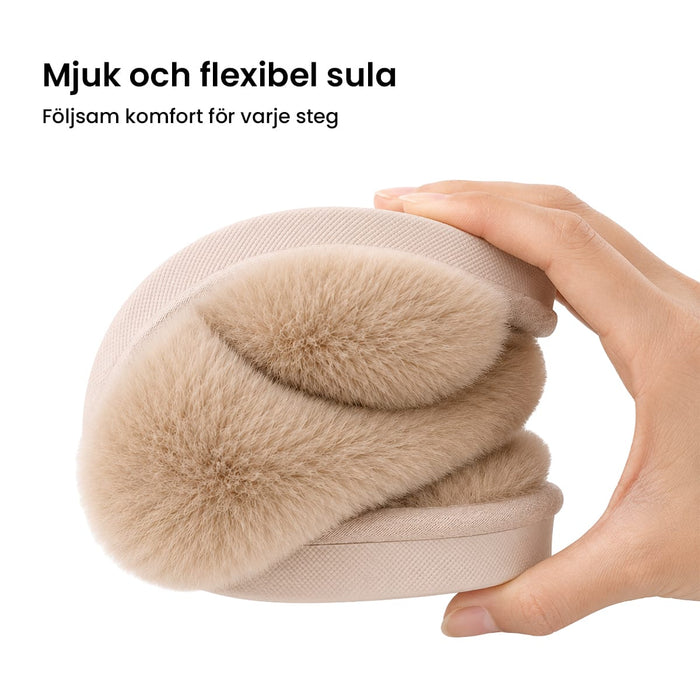 En hand böjer en beige vintertoffel från Kroppsbutiken för att visa upp dess mjuka, böjliga och halkfria sula.