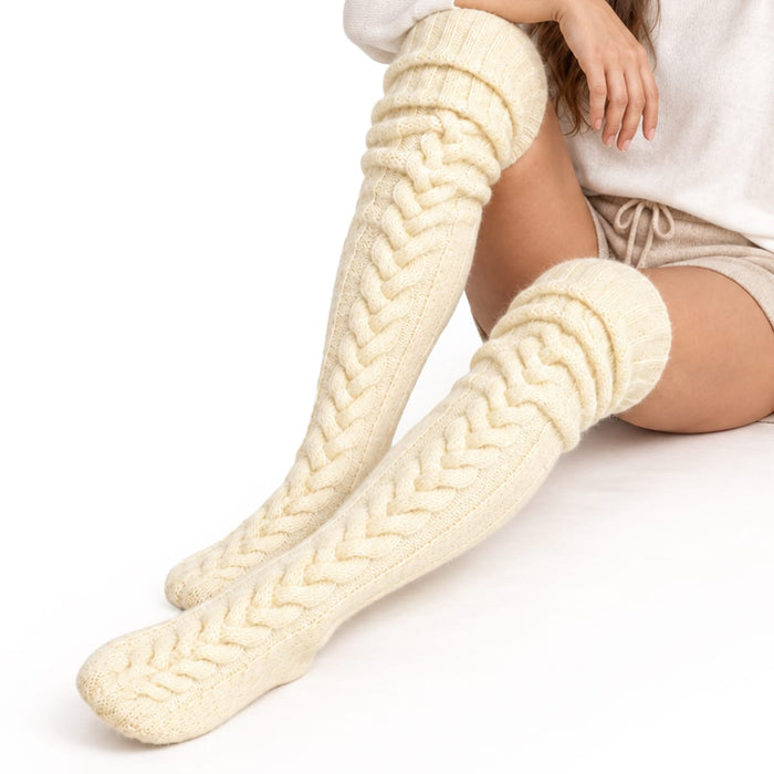 Krämvita, knähöga Cozysocks i flätstickat utförande.
