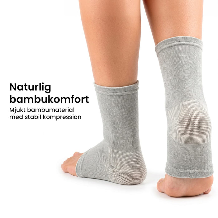 Två fötter i kompressionsstrumpor av bambu, med svensk text om materialets komfort.